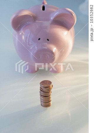 Stack of pennies in front of piggy bank 10352662
