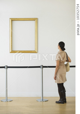 Woman looking at blank picture frame in art gallery Woman looking at blank picture frame in art gallery 10352754