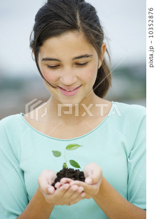 Girl (12-13) holding seedling Girl (12-13) holding seedling 10352876