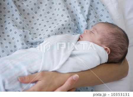 Newborn baby swaddles in mother's arms 10353131