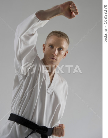 Young man performing karate stance on white background Young man performing karate stance on white background 10353270