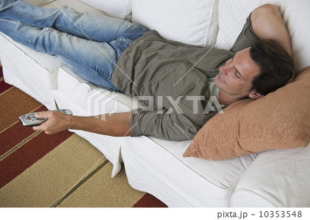 Man relaxing on sofa and watching TV Man relaxing on sofa and watching TV 10353548