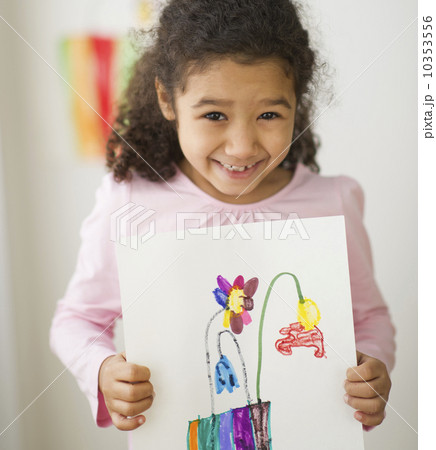 Smiling girl (6-7) showing her drawing 10353556