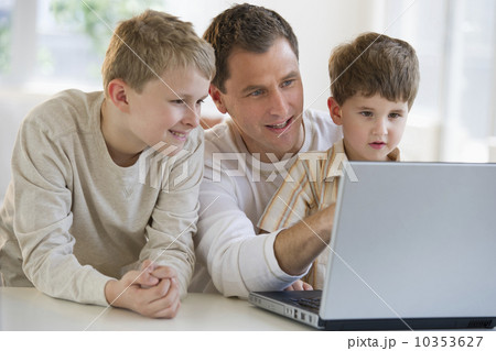 Father and sons looking at laptop 10353627