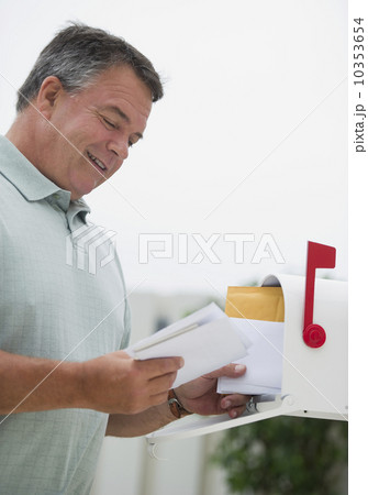 USA, New Jersey, Jersey City, Man checking mail in mailbox 10353654