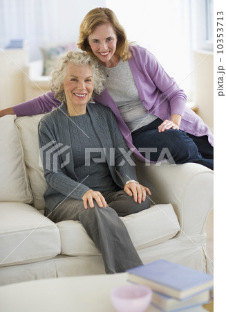 USA, New Jersey, Jersey City, Portrait of mother and daughter smiling on sofa USA, New Jersey, Jersey City, Portrait of mother and daughter smiling on sofa 10353713