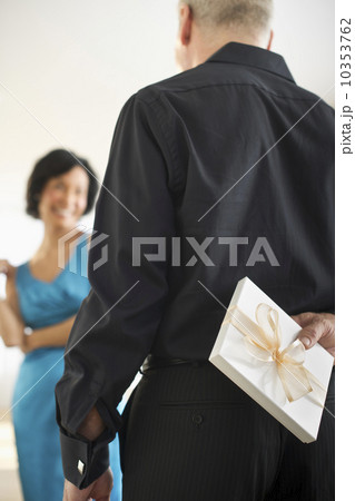 Man hiding gift box behind his back 10353762