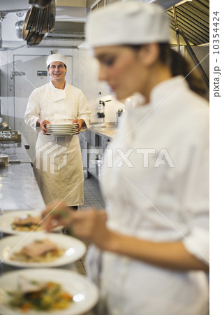 Chef and cook preparing food in commercial kitchen 10354424