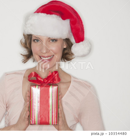 Portrait of smiling woman in Santa hat holding gift 10354480