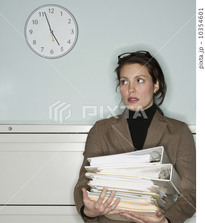Young woman in office holding stack of documents 10354601