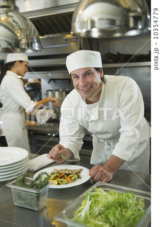 Chef and cook preparing food in commercial kitchen 10354779