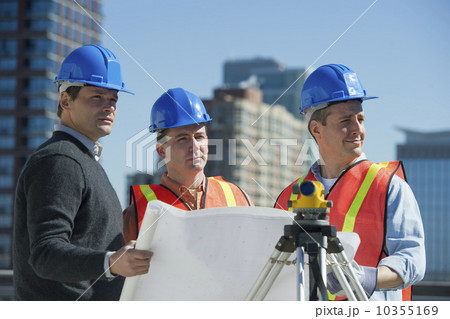 USA, New Jersey, Jersey City, construction workers reading blueprint 10355169
