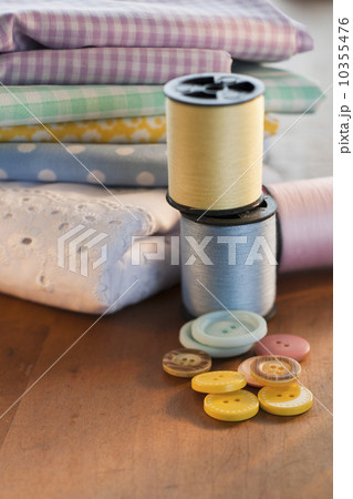 Close-up of thread, buttons and folded textiles Close-up of thread, buttons and folded textiles 10355476