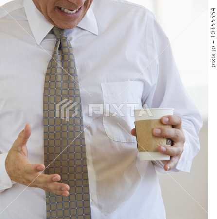 Businessman spilling coffee on shirt Businessman spilling coffee on shirt 10355554