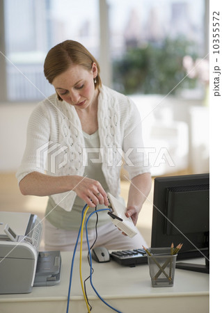 USA, New Jersey, Jersey City, woman installing router at home office 10355572