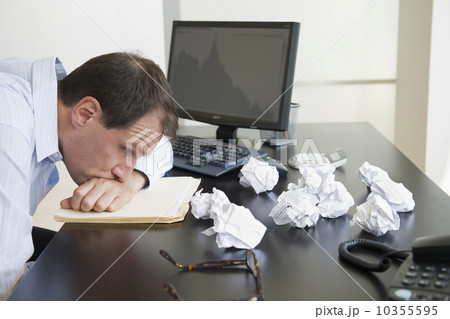 Businessman with face down on desk 10355595