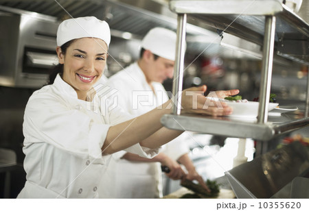 Chefs preparing food, woman looking at camera and smiling 10355620