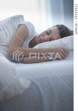 Happy young woman sleeping in bed 10355621