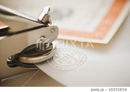 Close up of stamper making seal on paper 10355659