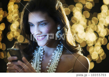Young woman at party text messaging Young woman at party text messaging 10355703