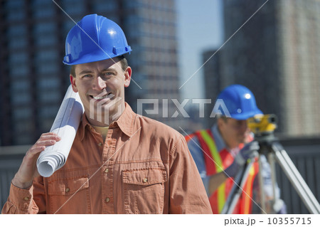 USA, New Jersey, Jersey City, portrait of construction worker holding rolled up blueprint 10355715