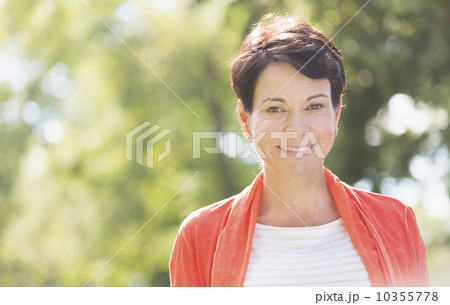 Happy mature woman raising hands in park Happy mature woman raising hands in park 10355778