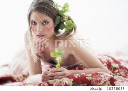 Studio portrait of young woman with flowers in hair 10356053