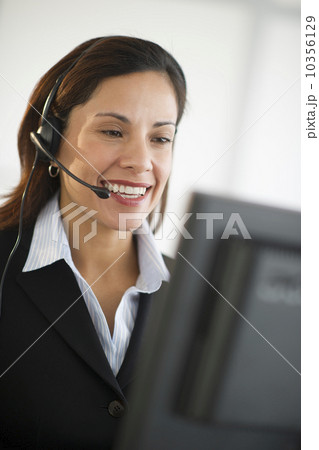 USA, New Jersey, Jersey City, smiling female customer service representative with headset 10356129