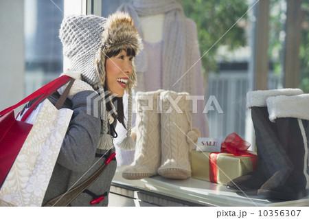 Smiling woman looking at shop display during Christmas shopping Smiling woman looking at shop display during Christmas shopping 10356307