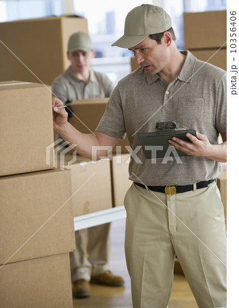 USA, New Jersey, Jersey City, man checking checklist in warehouse USA, New Jersey, Jersey City, man checking checklist in warehouse 10356406