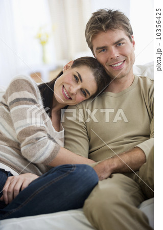 Portrait of happy couple sitting on sofa 10356425