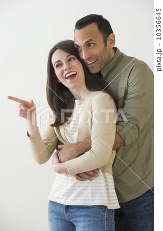 Happy couple embracing and looking away, studio shot Happy couple embracing and looking away, studio shot 10356645