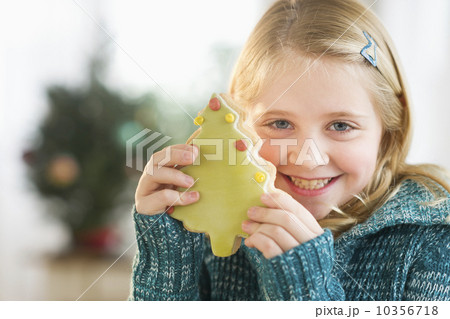 Girl (8--9) holding gingerbread cookie Girl (8--9) holding gingerbread cookie 10356718