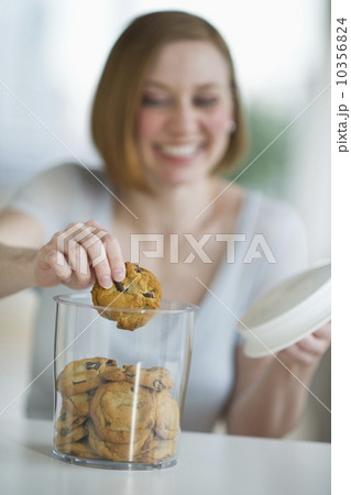 USA, New Jersey, Jersey City, woman eating cookies USA, New Jersey, Jersey City, woman eating cookies 10356824
