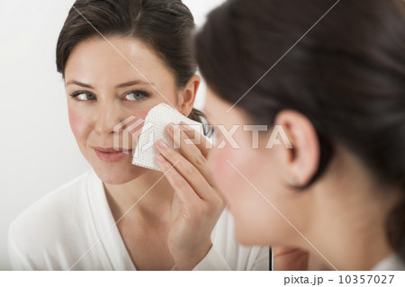 USA, New Jersey, Jersey City, woman removing make-up in bathroom 10357027