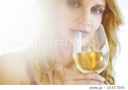 Portrait of young woman tasting wine, studio shot 10357095