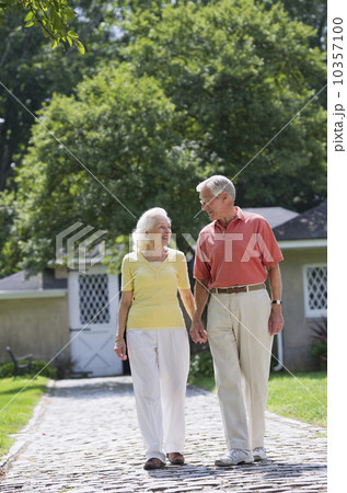 Senior couple walking in back yard 10357100