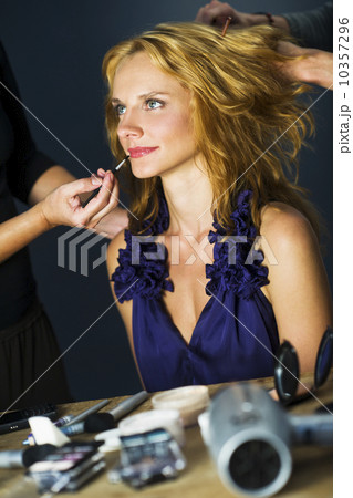 Woman having make-up applied by make-up artists, studio shot 10357296
