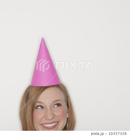 Studio shot of woman wearing pink party hat 10357326