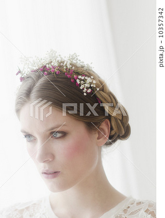 Pensive young woman with flowers in hair 10357342