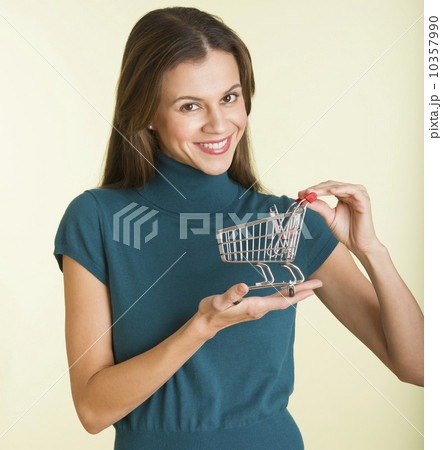 Studio shot of woman holding small shopping cart 10357990