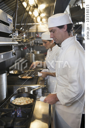 Chef and cook preparing food in commercial kitchen Chef and cook preparing food in commercial kitchen 10358015