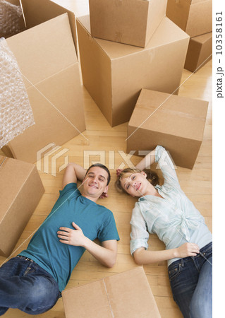 Couple lying among cardboard boxes during relocation 10358161