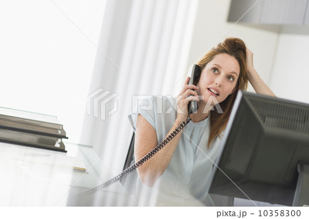 Business woman using computer and phone in office 10358300