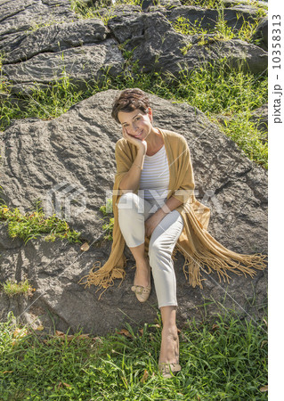 Mature woman sitting on rock 10358313