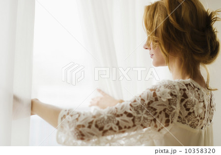 Woman looking out window 10358320
