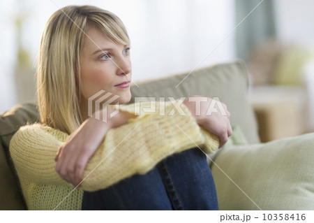 Pensive woman sitting on sofa 10358416
