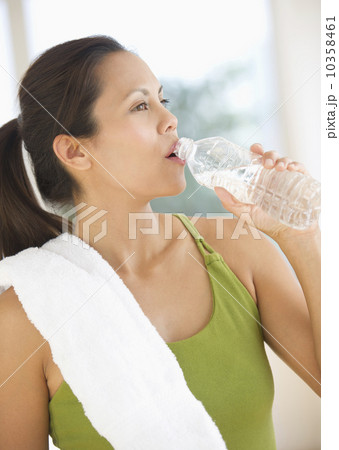 Woman drinking water after training Woman drinking water after training 10358461