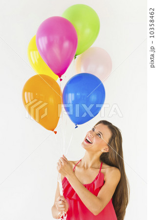 Smiling woman holding balloons, studio shot 10358462