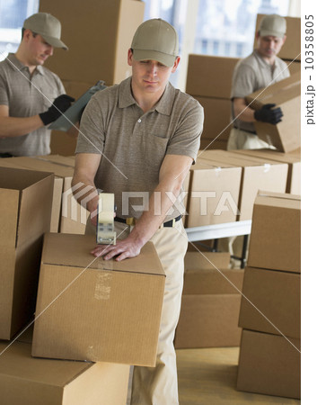 USA, New Jersey, Jersey City, men packing boxes in warehouse 10358805